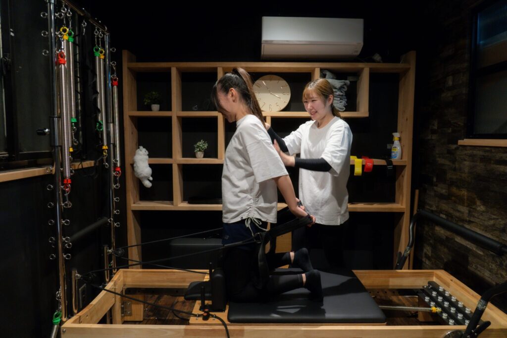 ピラティストレーニングを受けている女性2