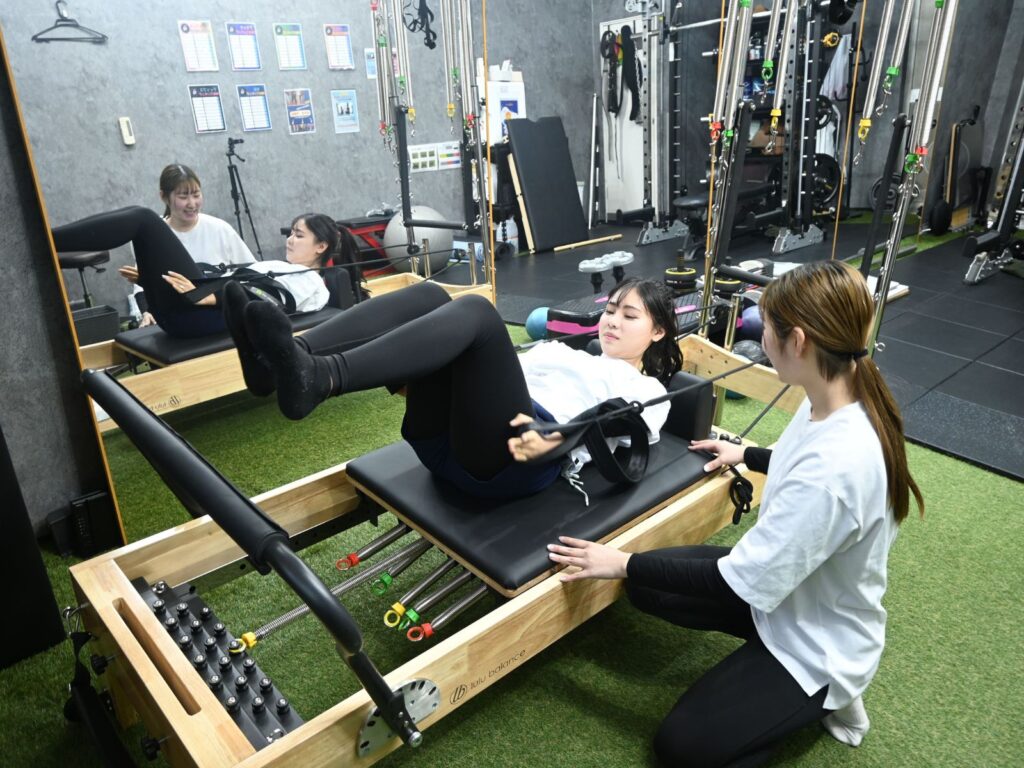 マンツーマンマシンピラティスNEXT八尾店でピラティスをしている女性